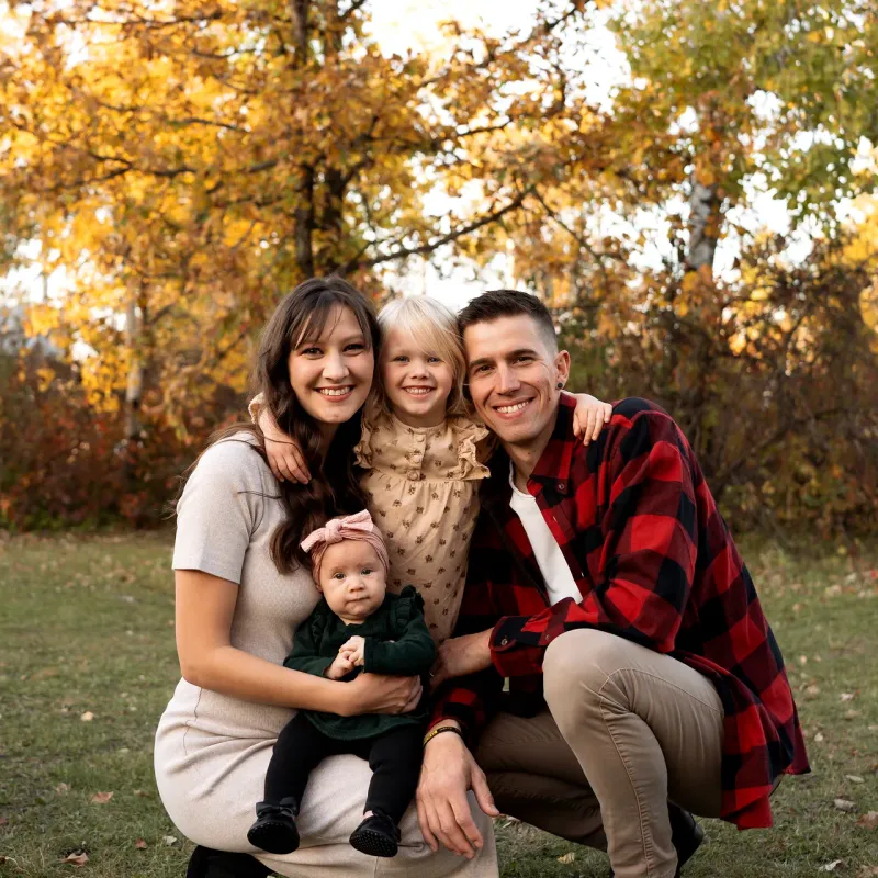 Marko and Shirley Sawatzky with their daughters Hannah and Zaira, outdoors among autumn trees