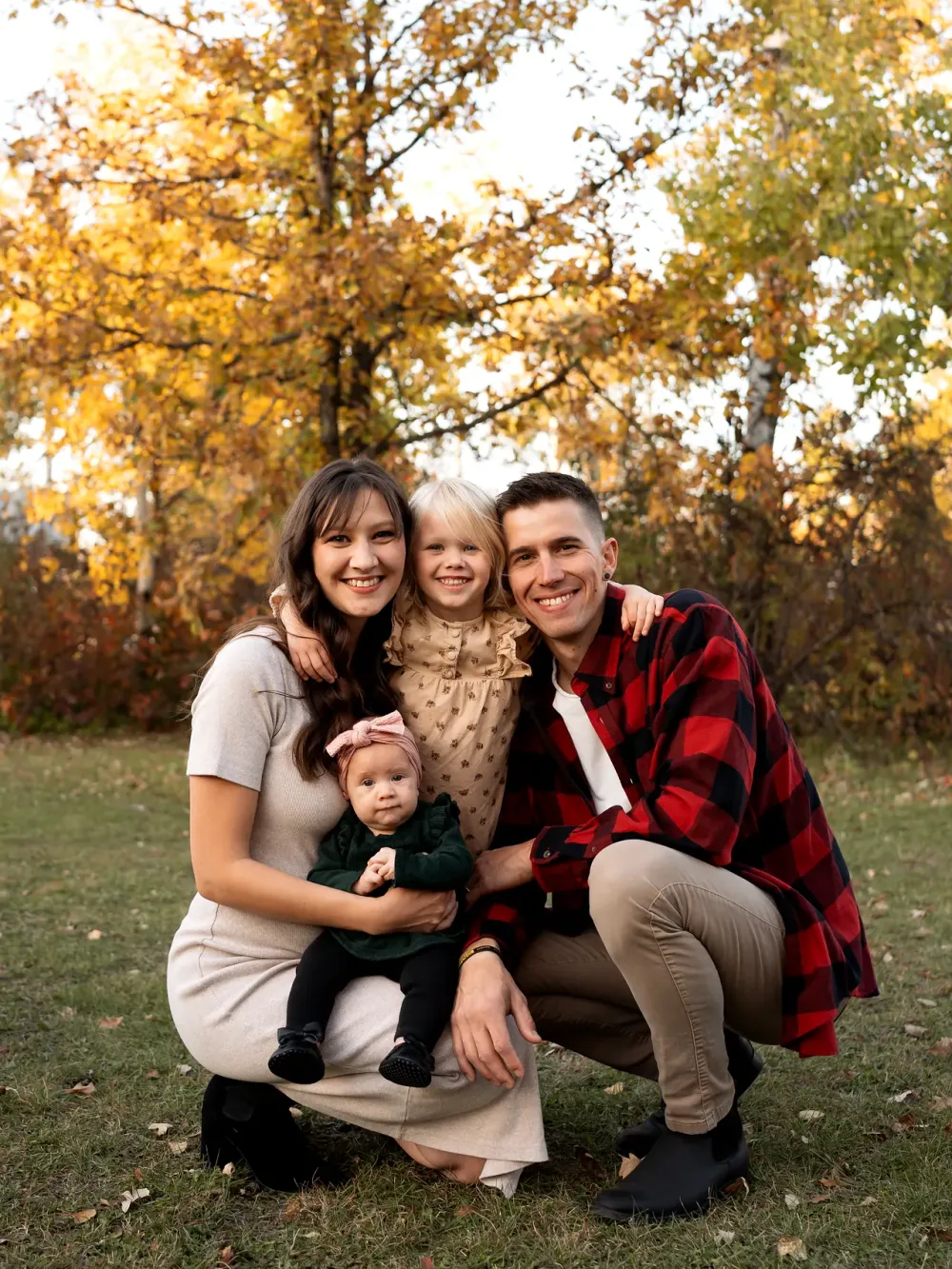 Marko and Shirley Sawatzky with their daughters Hannah and Zaira, outdoors among autumn trees