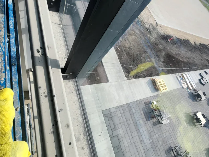 Window frame and sill inside a new commercial building, grey with dust and spots, seen from a lift