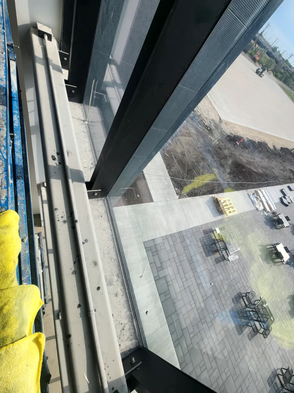 Window frame and sill inside a new commercial building, grey with dust and spots, seen from a lift